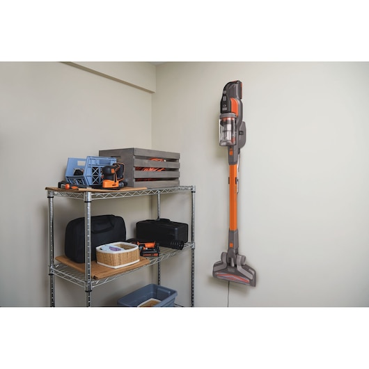 BLACKDECKER BHFEV182B aspirateur balai sans fil fixé au mur près d'une étagère, intérieur.