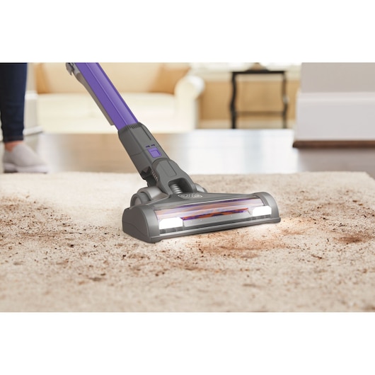 BLACKDECKER BHFEV182CP aspirateur sans fil nettoyant la saleté sur tapis dans salon, vue rapprochée.