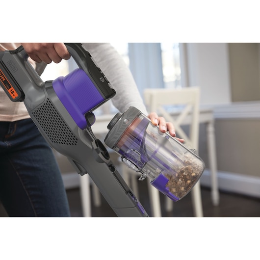 Aspirateur sans fil BLACKDECKER BHFEV182CP utilisé, vidange du réservoir à poussière en intérieur.