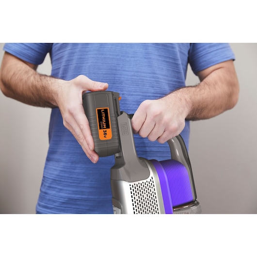 Aspirateur sans fil BLACKDECKER BHFEV362DP avec batterie lithium 36V en cours d’insertion, gros plan sur la poignée et la batterie.