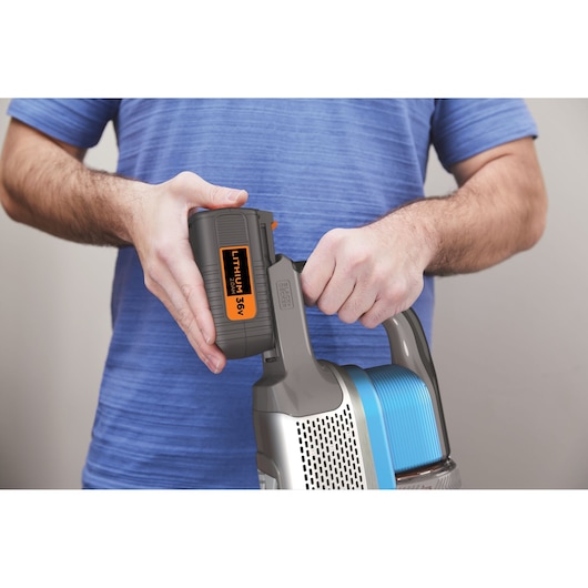 Aspirateur BLACK+DECKER BHFEV362D gros plan avec une personne fixant la batterie amovible lithium 36V.