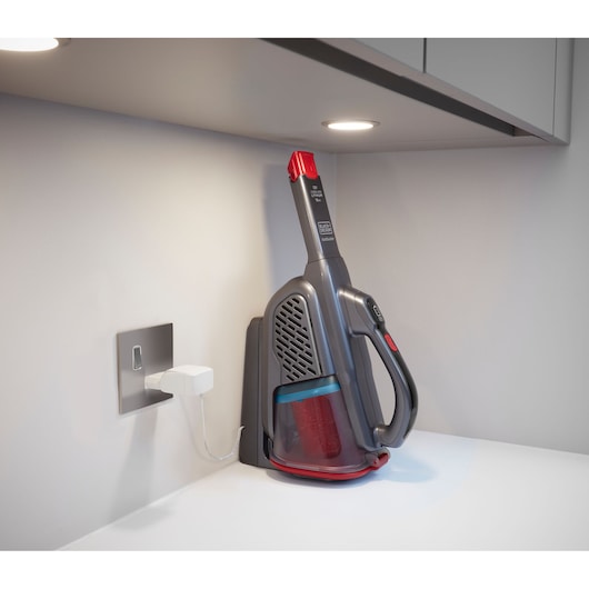 BLACKDECKER BHHV315B handstofzuiger aan het opladen op een wit aanrecht, zijaanzicht.