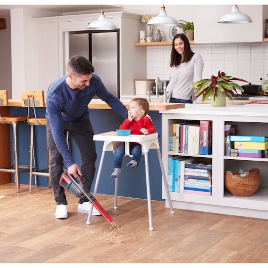 BLACKDECKER BHHV315J handstofzuiger zuigt kruimels op keukenvloer bij kinderstoel.