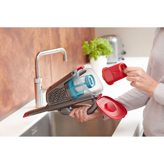 BLACKDECKER BHHV315J handstofzuiger toont filterverwijdering boven keukenspoelbak.