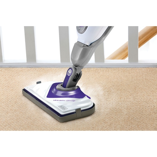 BLACKDECKER BHSM1615DSM stoommop reinigt beige tapijt, close-up van de mopkop in gebruik.
