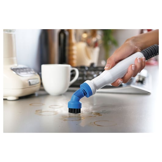 BLACKDECKER BHSM1615DSM handreiniger met blauwe borstelopzet verwijdert vlekken op aanrechtblad.