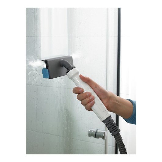 BLACKDECKER BHSM1615DSM stoomreiniger reinigt glazen douchedeur, close-up van hand aan handvat.