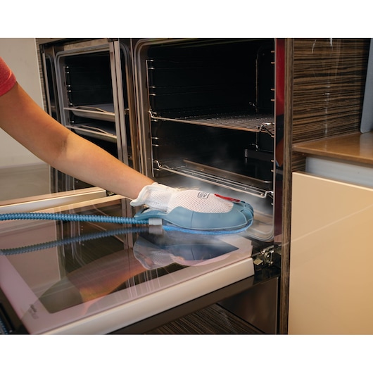 BLACKDECKER BHSM168DSM stoomreinigingshandschoen wordt gebruikt om ovenruit te reinigen, blauwe slang bevestigd.