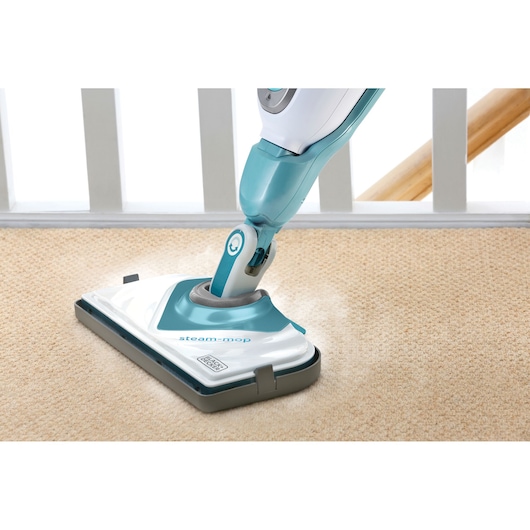 BLACKDECKER BHSM168U stoomreiniger reinigt beige tapijt, close-up van de mopkop in gebruik.