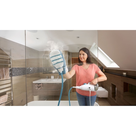 BLACK+DECKER BHSM169DSM stoomreiniger met reinigingshandschoen-accessoire in gebruik op een badkamerspiegel.