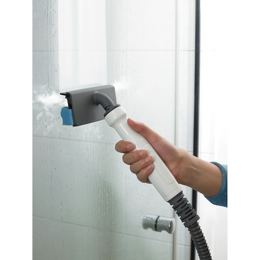 BLACKDECKER BHSM169DSM stoomreiniger wordt gebruikt om een glazen douchedeur te reinigen, close-up.
