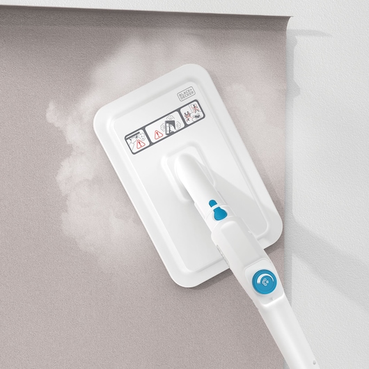 BLACK+DECKER BHSMP2314 stoommop reinigt grijs tapijt, detail bovenaanzicht, met handvat en bedieningsknoppen.