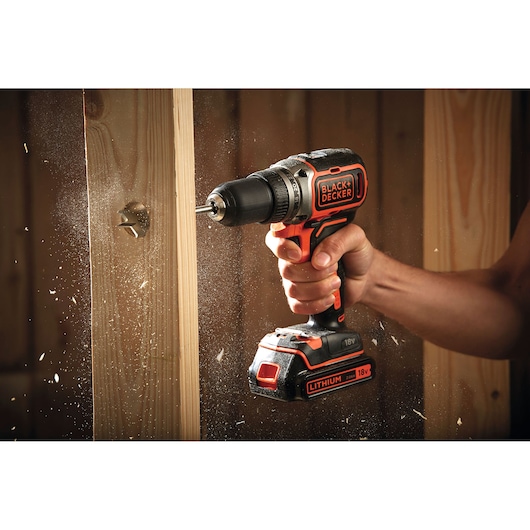 BLACK+DECKER BL186K1B2 perceuse sans fil perçant du bois, vue rapprochée avec copeaux volants.