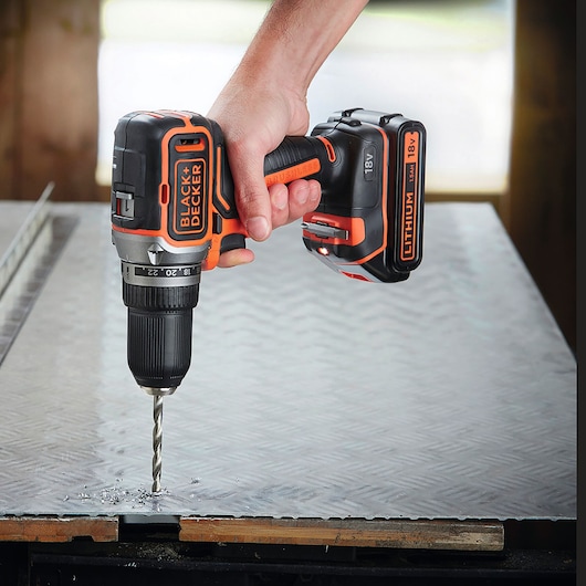 BLACKDECKER BL186N perceuse sans fil utilisée pour percer une plaque métallique, vue rapprochée.