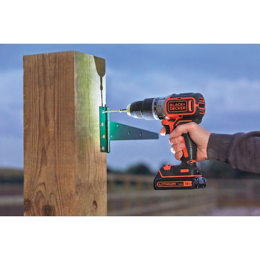 BLACKDECKER perceuse sans fil BL188N fixant un support à un poteau en bois en extérieur.