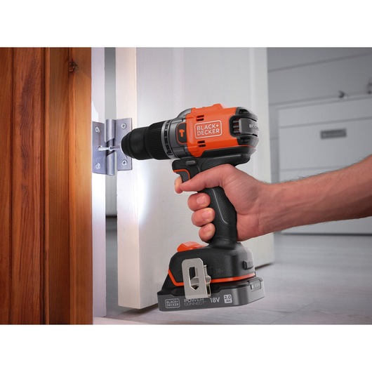 BLACKDECKER BLD683D1 perceuse sans fil utilisée sur charnière de porte, vue rapprochée.