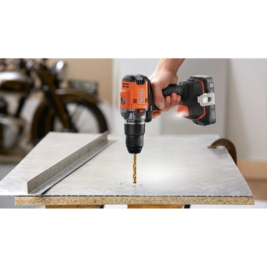 BLACKDECKER perceuse sans fil BLD683D1 perçant une plaque métallique, photographie en gros plan.