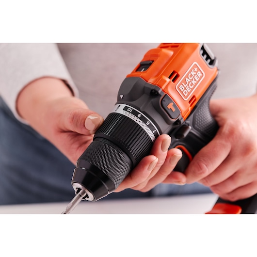 Photo en gros plan de la perceuse sans fil BLACK+DECKER BLD683XN, orange et noire, ajustée à la main.