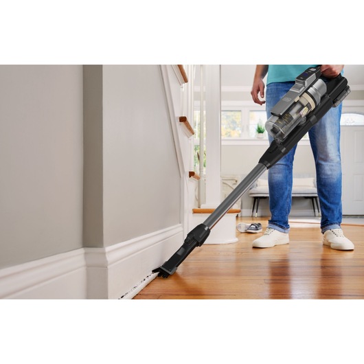 BLACKDECKER BSV520BL2P snoerloze steelstofzuiger reinigt plint in woonkamer.