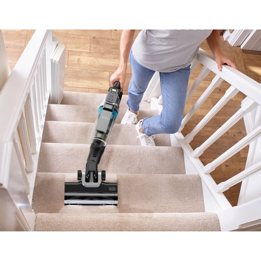 BLACKDECKER BSV520BRB snoerloze steelstofzuiger gebruikt op beklede trap, van bovenaf gezien.