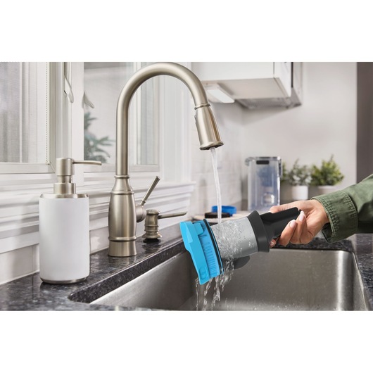 BLACK+DECKER BSV520BRB stofzuigerfilter wordt afgespoeld onder een keukenkraan, close-up.