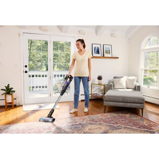 BLACKDECKER BSV520BRP snoerloze steelstofzuiger in gebruik op houten vloer en kleed in een lichte woonkamer.