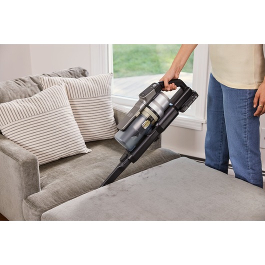 BLACKDECKER BSV525BLP snoerloze steelstofzuiger reinigt een bank, handmodus met kierenzuigmond.