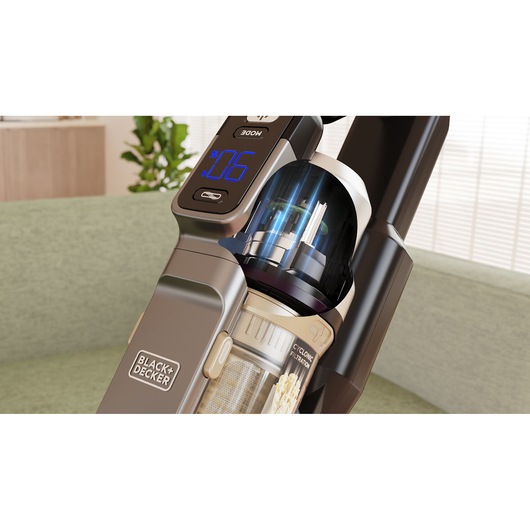Foto van BLACK+DECKER BSV520BLP snoerloze stofzuiger close-up met digitaal display en cycloonfilter in huiselijke omgeving.