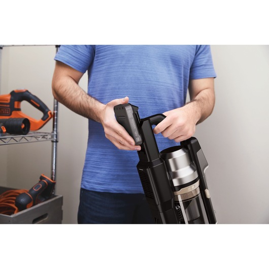 BLACKDECKER BSV525BLP snoerloze stofzuiger, close-up zijaanzicht van persoon die batterij plaatst.