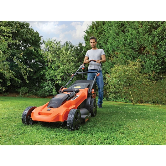 BLACKDECKER CLMA4820L2 tondeuse à gazon utilisée sur de l'herbe par une personne, design orange et noir.