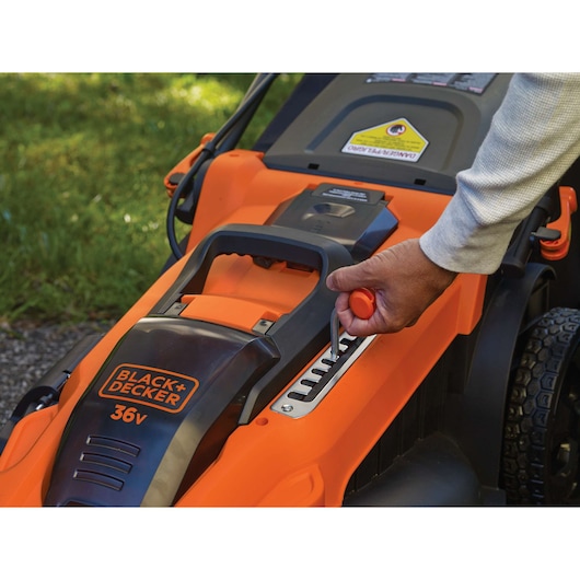 Photo de la tondeuse 36V BLACK+DECKER CLMA4820L2 avec une main réglant le levier de hauteur.