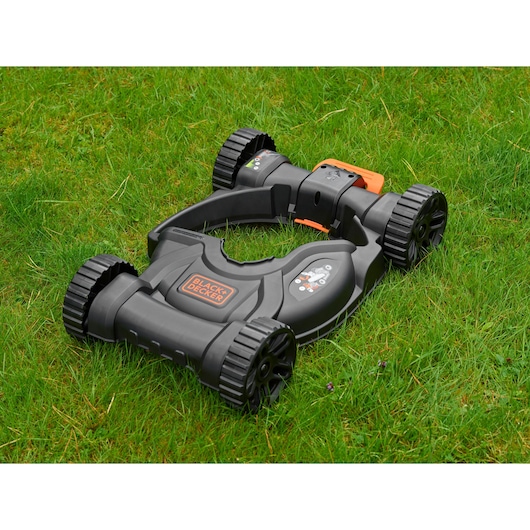 BLACKDECKER CM100 grasmaaier accessoire in zwart en oranje op gras, zijaanzicht.