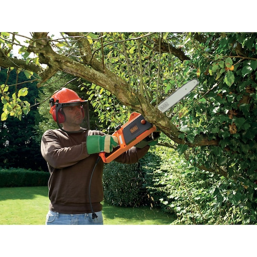 BLACKDECKER CS1840 kettingzaag voor het zagen van takken buiten, oranje en zwart ontwerp, product in actie.