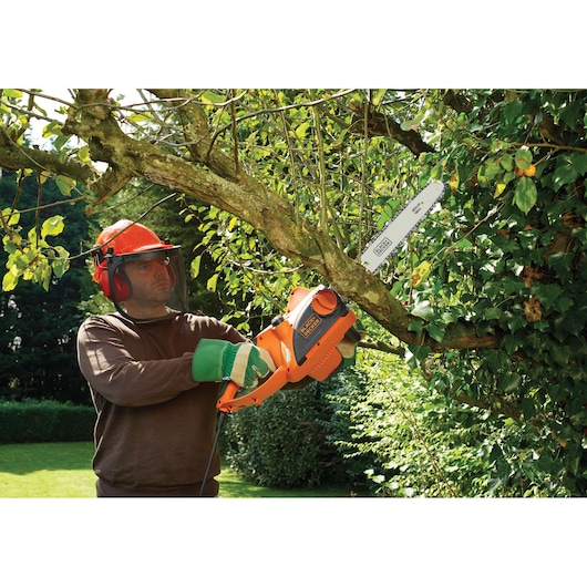 BLACKDECKER CS2040 kettingzaag gebruikt buiten voor takken zagen, zichtbaar oranje behuizing en zaagblad.