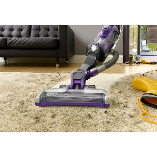 BLACKDECKER CUA625BHP aspirateur lithium sans fil nettoyant tapis beige dans salon, photographie en contre-plongée.