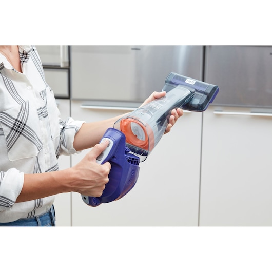 Foto van BLACK+DECKER DVB315JP handstofzuiger met paarse en oranje accenten, gebruikt binnenshuis.