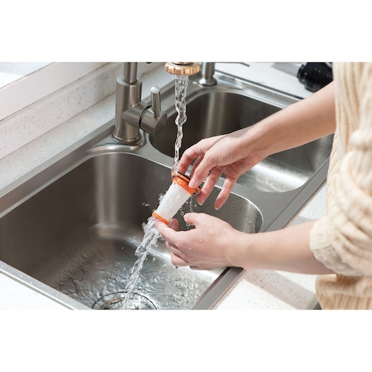 BLACKDECKER DVC320B21 stofzuigerfilter afgespoeld onder kraan in keukenspoelbak.