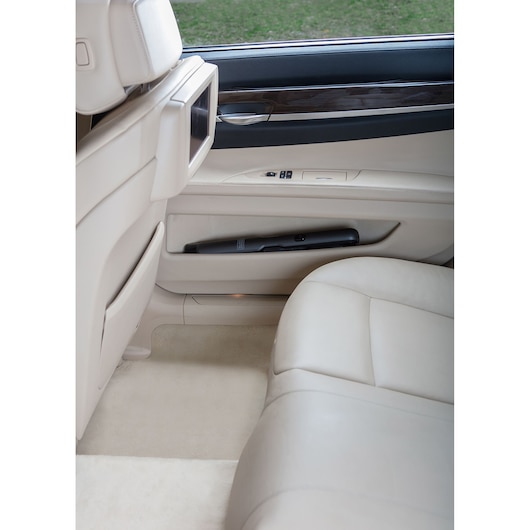 BLACKDECKER DVC320B21 handstofzuiger opgeborgen in beige autoportier vak, foto vanaf passagierszijde.