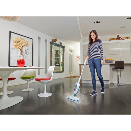 BLACKDECKER FSM13E1 balai vapeur nettoyant le sol de la cuisine, coin repas moderne et chaises visibles.