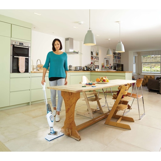 BLACKDECKER FSM1615 balai vapeur utilisé sur sol carrelé dans une cuisine et salle à manger moderne.