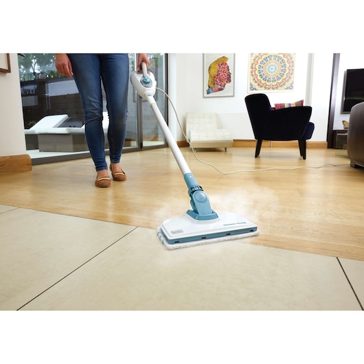 BLACKDECKER steam mop FSMH1300FX reinigt de vloer in een moderne woonkamer, vooraanzicht.