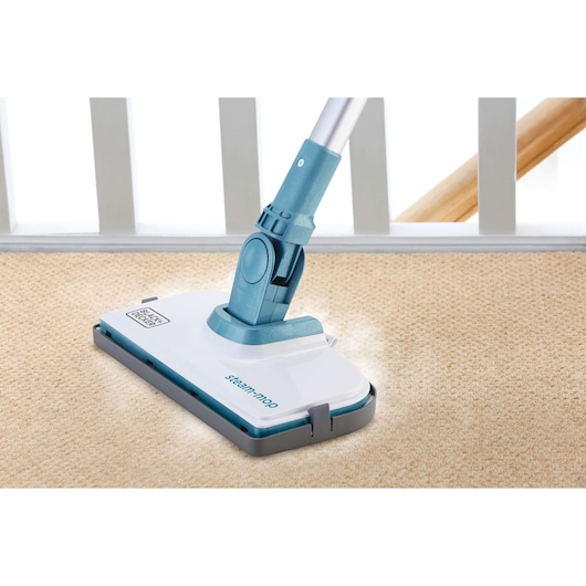 BLACKDECKER FSMH1300FX stoommop reinigt beige tapijt, close-up hoekweergave.