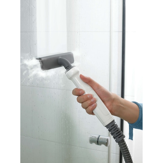 BLACKDECKER FSMH1321 stoomreiniger handgreep reinigt tegelwand met grijze opzetstuk, zijaanzicht.