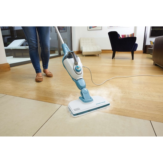 BLACKDECKER FSMH1321 stoommop reinigt houten en tegelvloer in een moderne woonkamer.