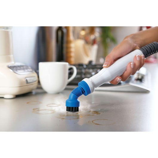 BLACKDECKER FSMH1321 stoomreinigerborstel reinigt een bevlekte keukenblad.