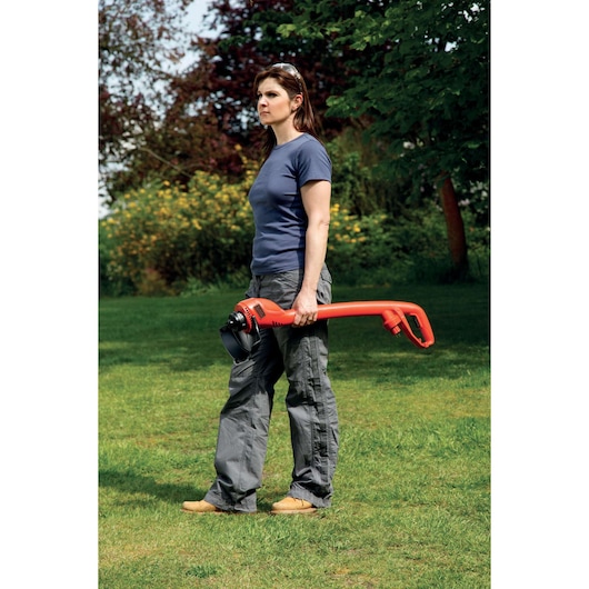 Photographie du coupe-bordure BLACKDECKER GL250 tenu par une personne sur une pelouse.