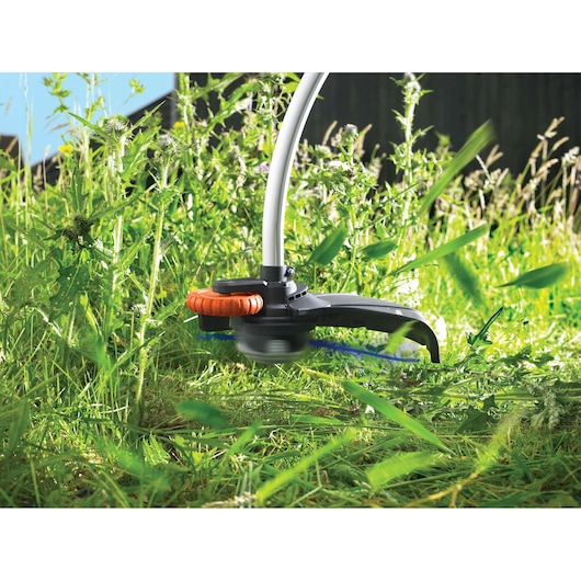 BLACKDECKER GL7033CAKIT grastrimmer close-up maait hoog groen gras buiten.