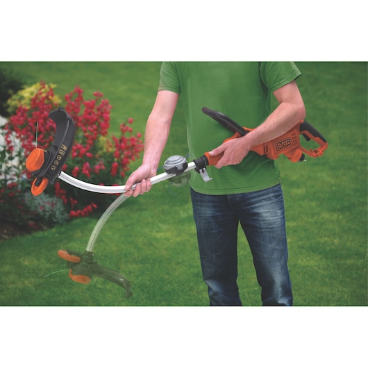 BLACKDECKER GL9035 grastrimmer in gebruik, oranje en zwart, getoond op een tuin gazon.