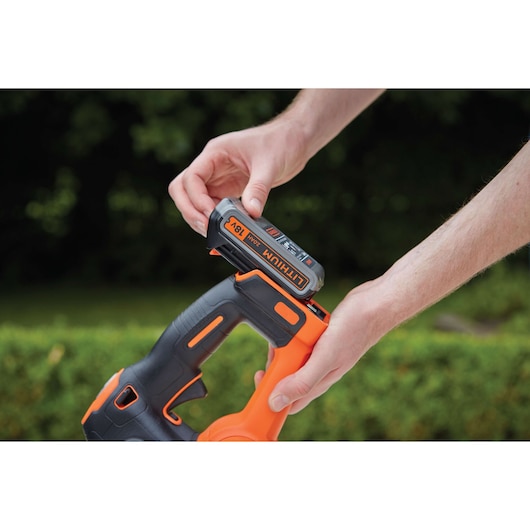 BLACKDECKER GTC18452PC heggenschaar met 18V lithium batterij die buiten wordt geplaatst.
