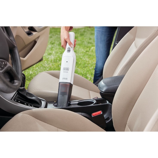 BLACKDECKER HLVC315B11 handstofzuiger gebruikt voor het schoonmaken van een auto-interieur.